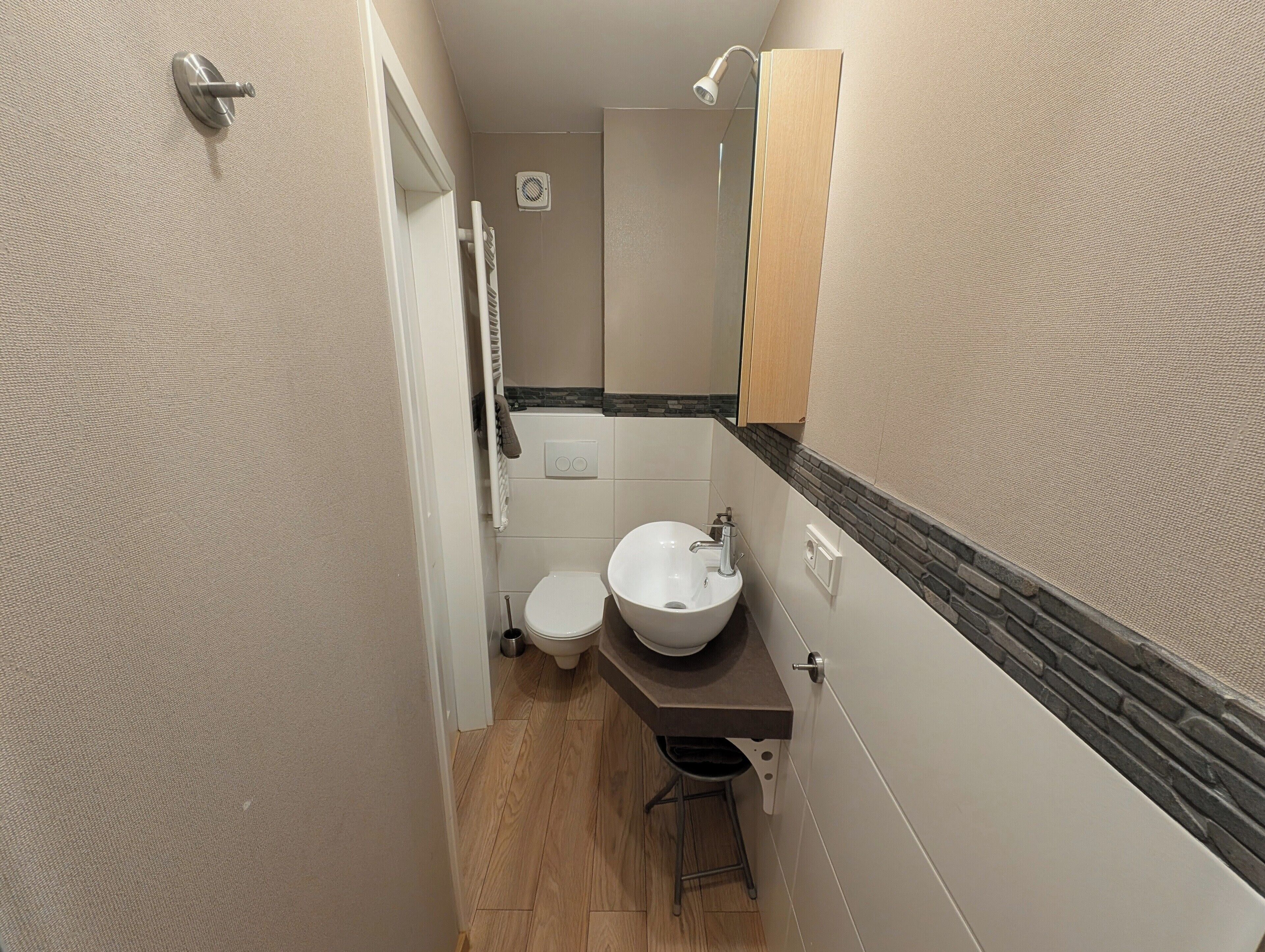 Ein kleines Badezimmer mit Toilette, Waschbecken und Handtuchhalter.