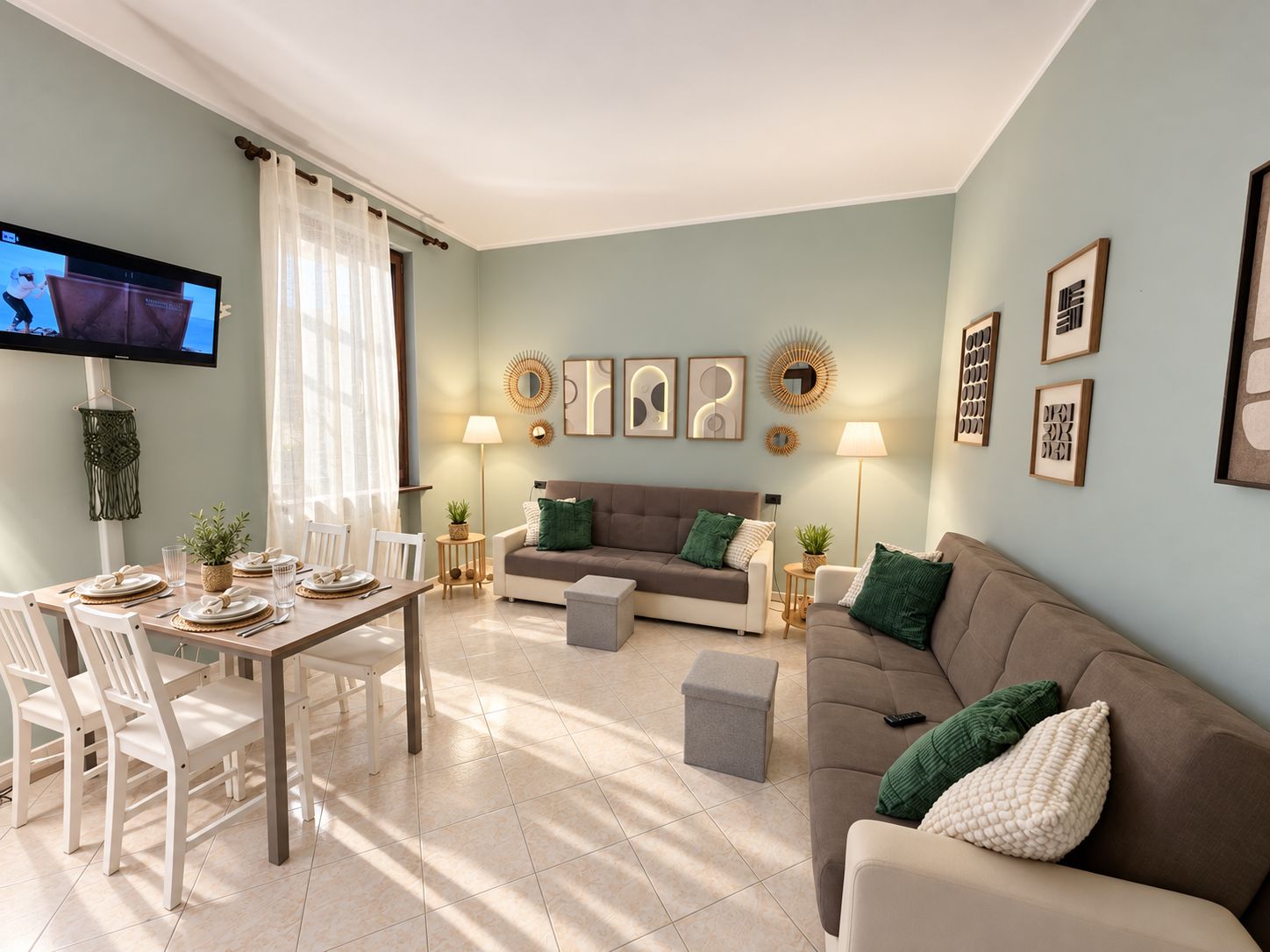 Un soggiorno con angolo pranzo, un divano, una TV e decorazioni a parete.