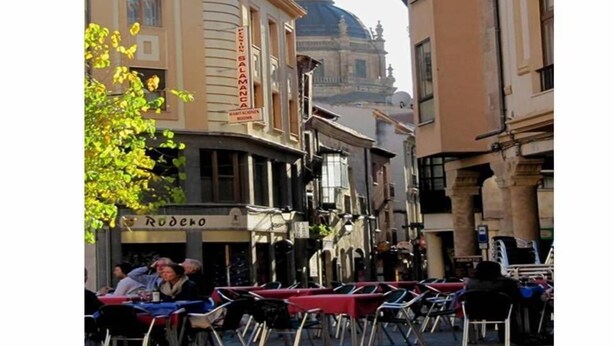 Vista da rua com um restaurante chamado 'Rudero' e um edifício com uma placa 'Sala Manca'.