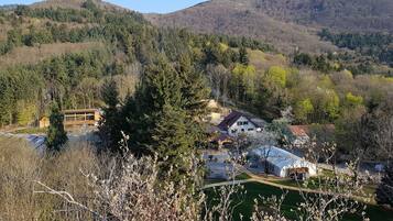A residential area with a house surrounded by trees and hills.