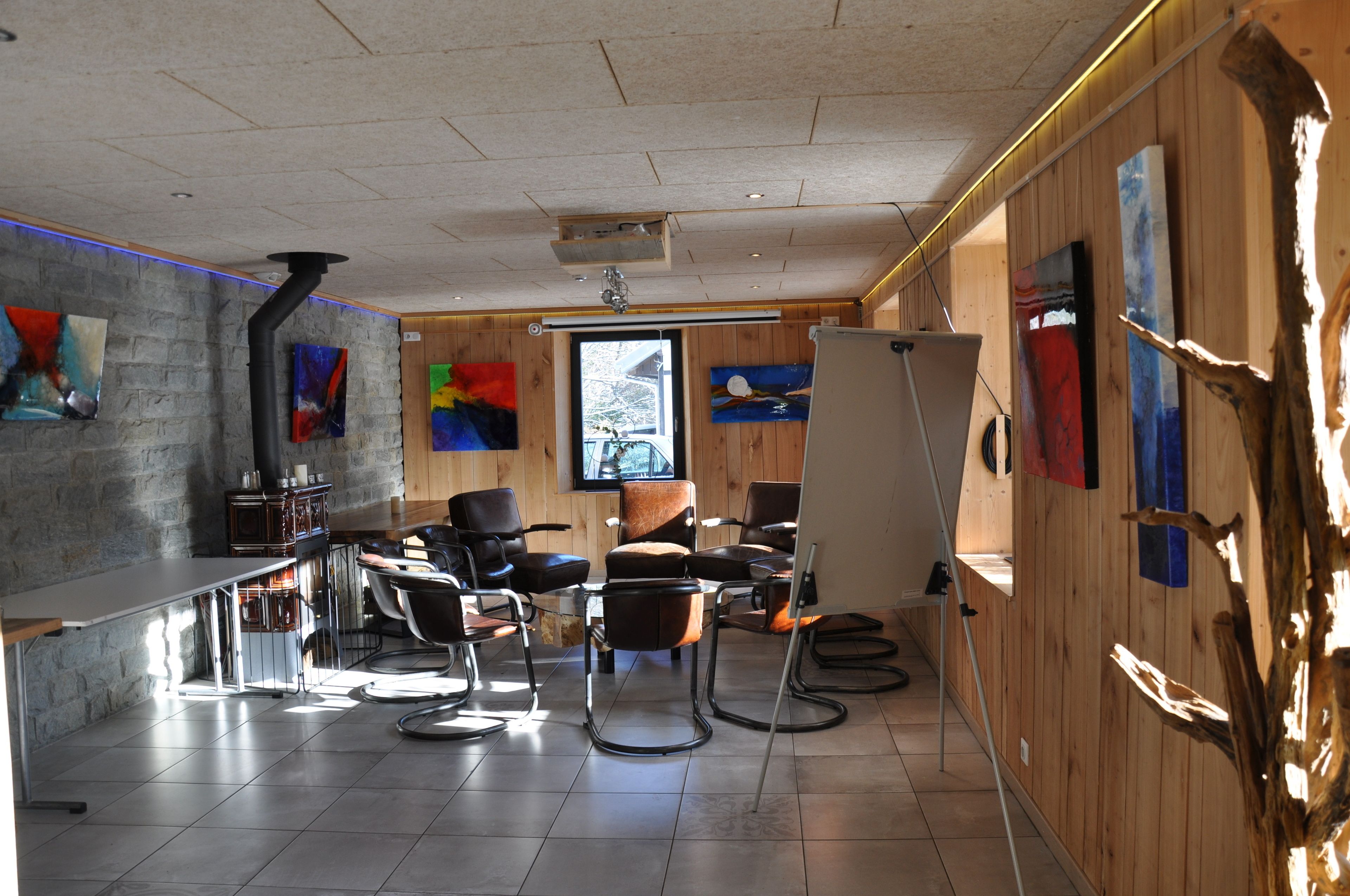 Een modern interieur met een bar, zitplaatsen en kunstwerken aan de muur.