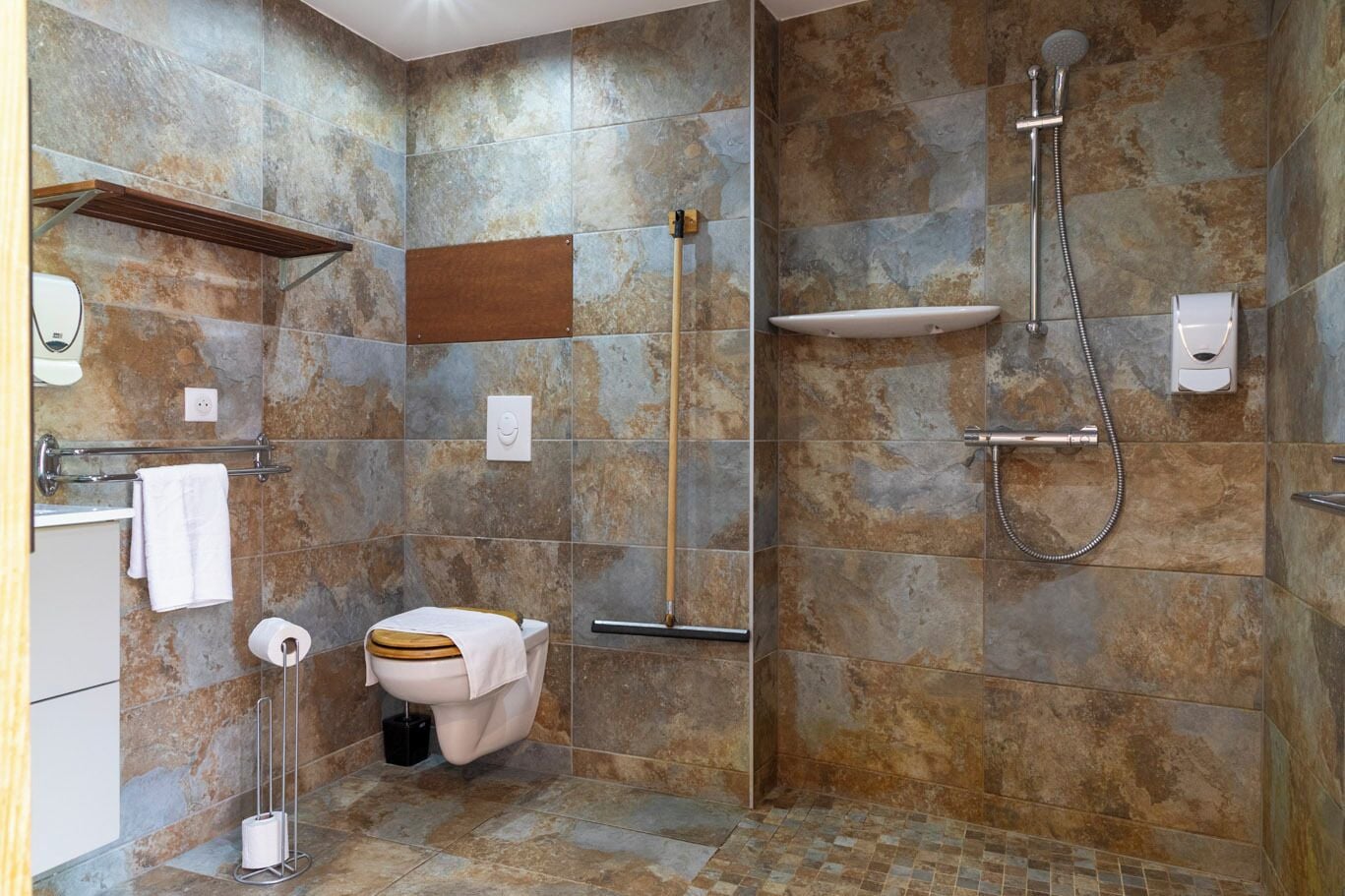 A modern bathroom with a shower, toilet, and sink.