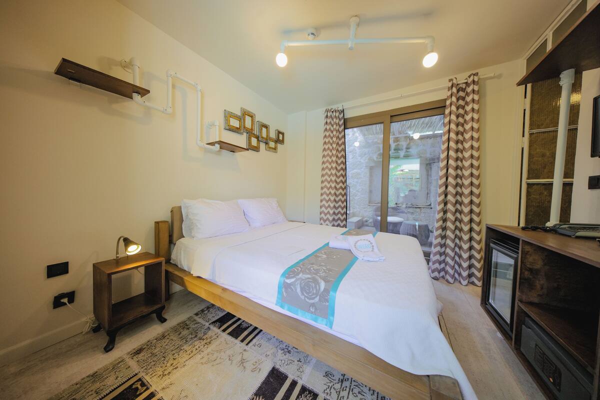 A bedroom with a bed, bedside table, and a television.