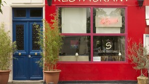 A red building with a blue door and windows, labeled "RESTAURANT" and "CUISINE TRADITIONNELLE". - La Villa Paris (Paris)