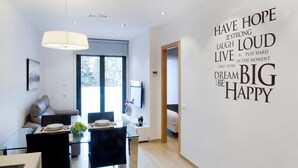A modern living room with a dining area, a large window, and motivational wall art. - Home To Home Barcelona (Barcelona)