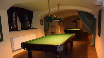 A pool table in a room with a tiled floor and a radiator.