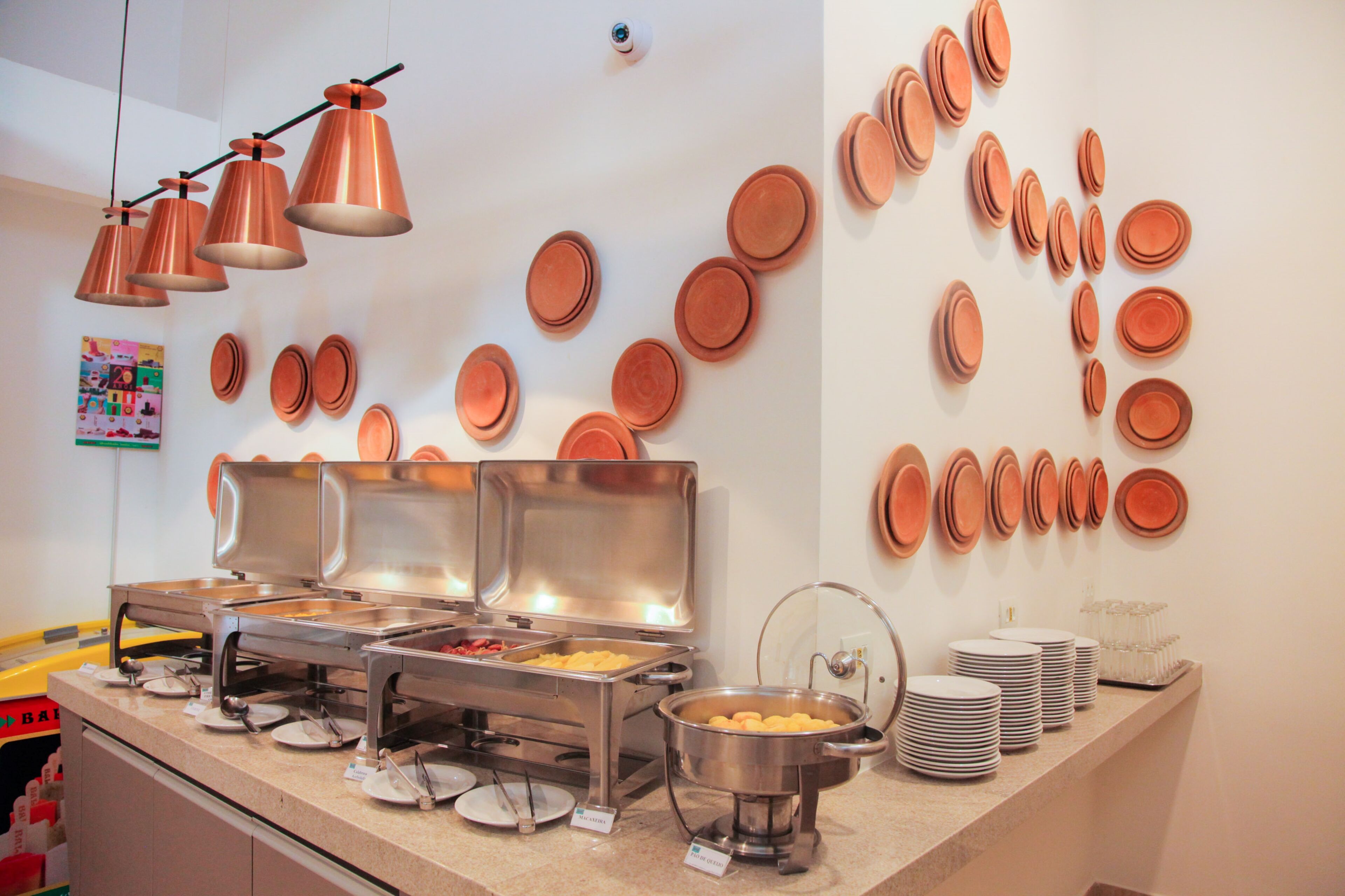 A buffet area with multiple food stations, including a hot pot and a fruit tray.