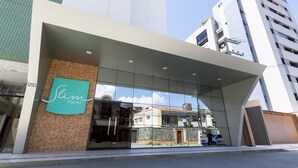 A hotel entrance with a modern design, large glass windows, and a prominent logo. - Slim Pajuçara by Tropicalis (Maceió)