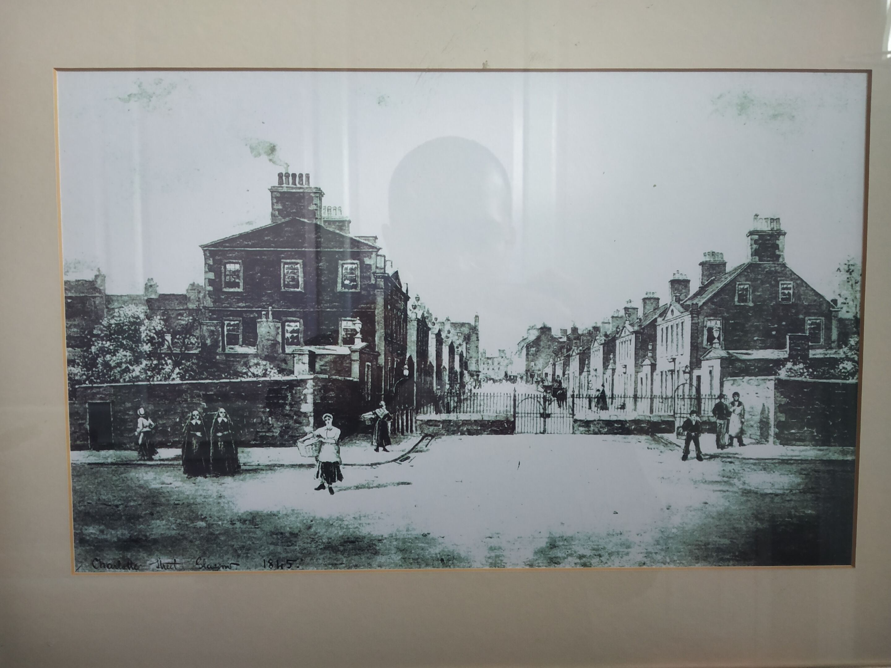 A historical street scene with buildings, a central archway, and people.