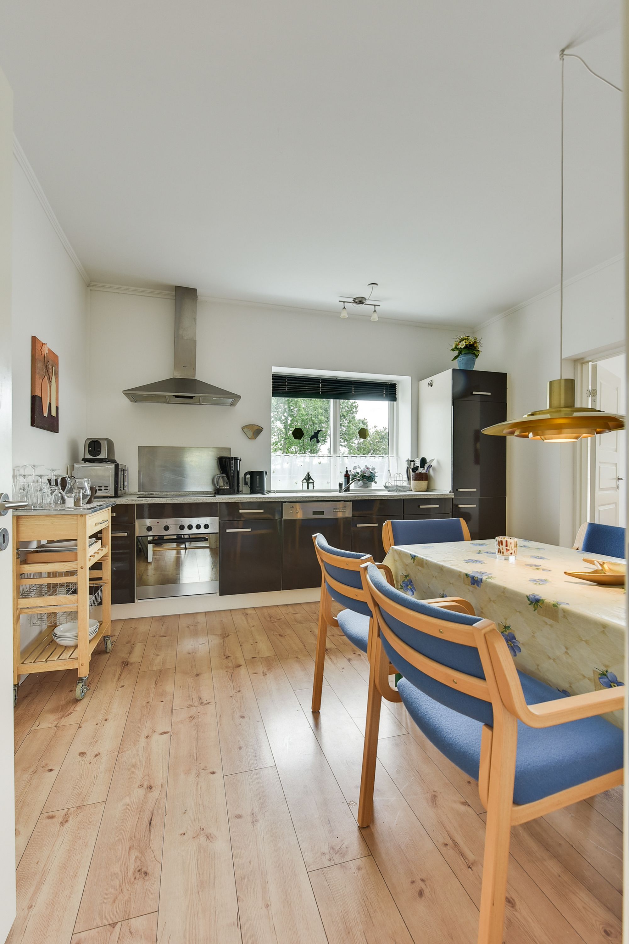 A modern kitchen with a central island, built-in oven, and stainless steel appliances.
