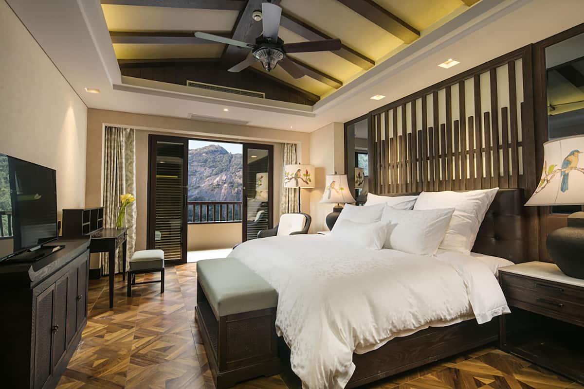 Un dormitorio con cama, televisor, escritorio y silla.