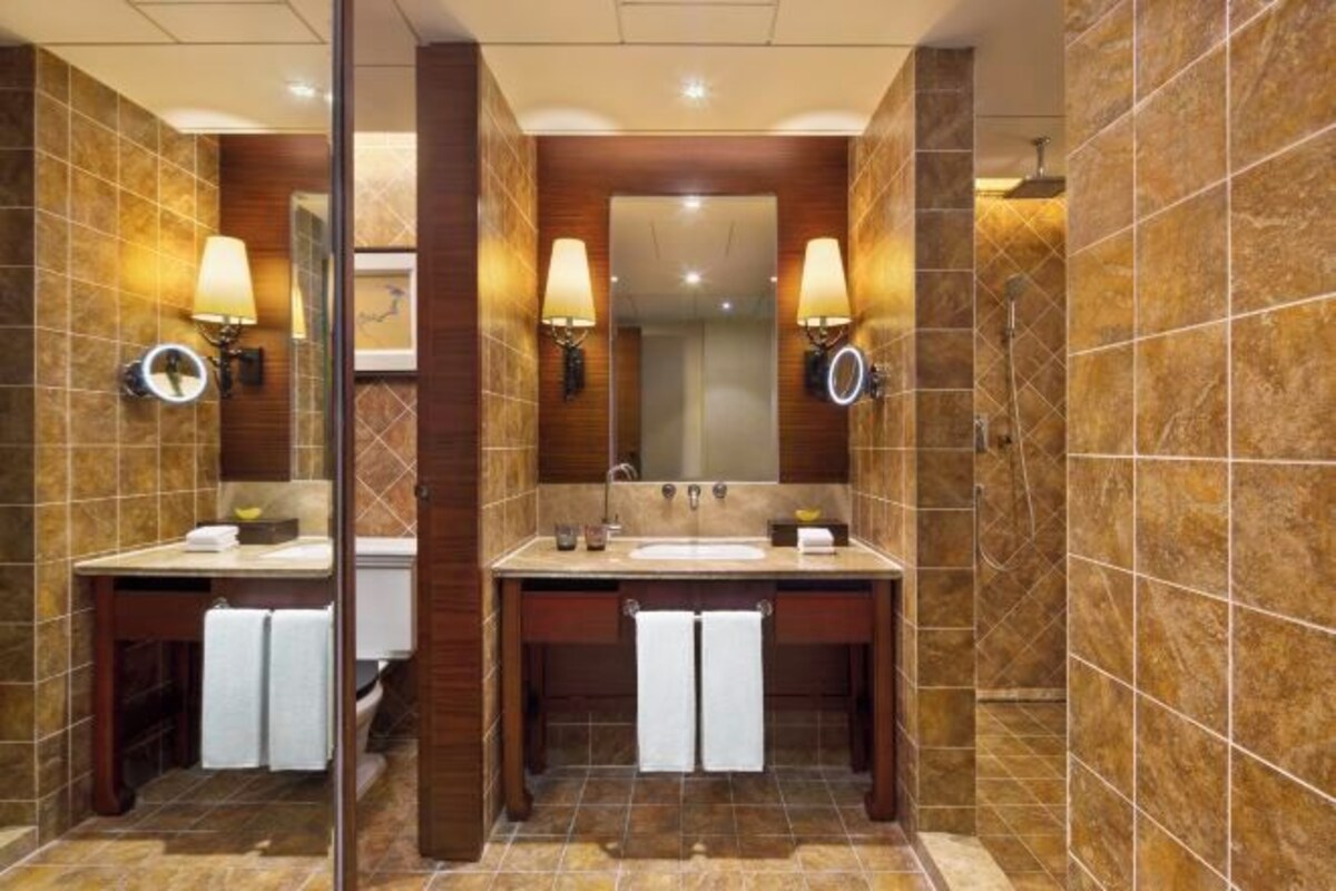 Un baño moderno con dos lavamanos, un espejo grande e iluminación en la pared.