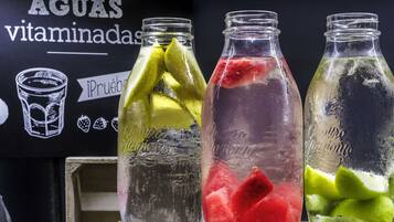 Three glass bottles with different colored liquids and lime slices.