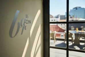 Una ventana con vista a un edificio y muebles de exterior.