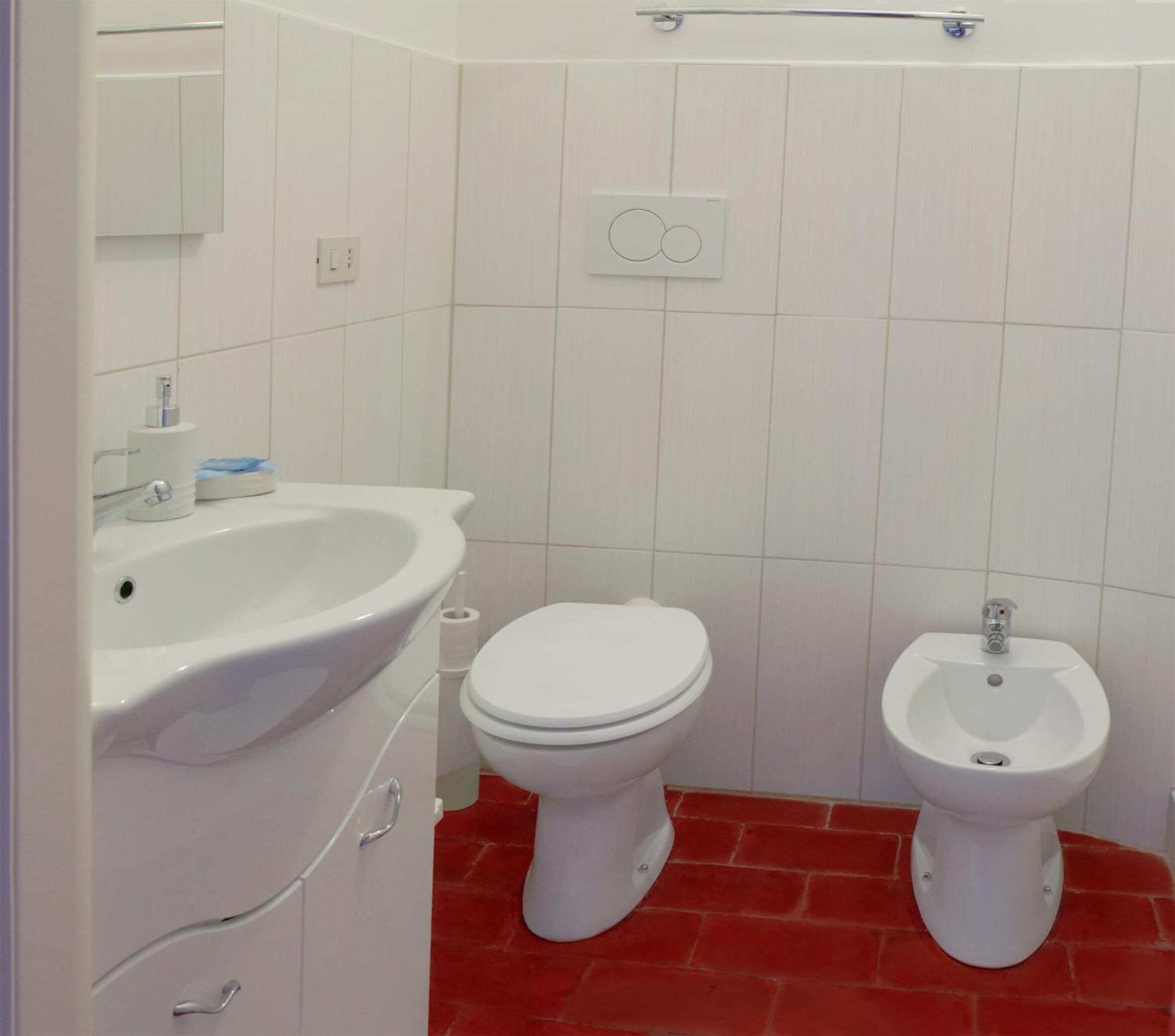 A small bathroom with a toilet, bidet, and sink.