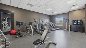 A gym with treadmills, elliptical machines, and free weights.