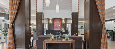 A lobby with a reception desk, a coffee table, and a seating area.
