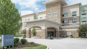 A hotel entrance with a stone facade, a covered walkway, and a sign indicating 'Homewood Suites by Hilton.' - Homewood Suites by Hilton Munster (Munster)
