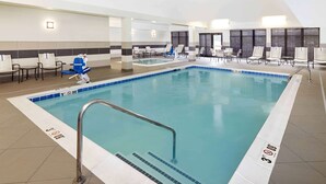 An indoor swimming pool with a clear waterline, a metal pool ladder, and a tiled floor. - Homewood Suites by Hilton Munster (Munster)