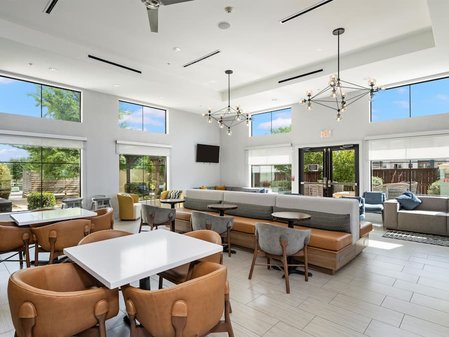 Un espacio interior amplio con un conjunto de asientos, una mesa de comedor y un gran ventanal que ofrece vistas al exterior.