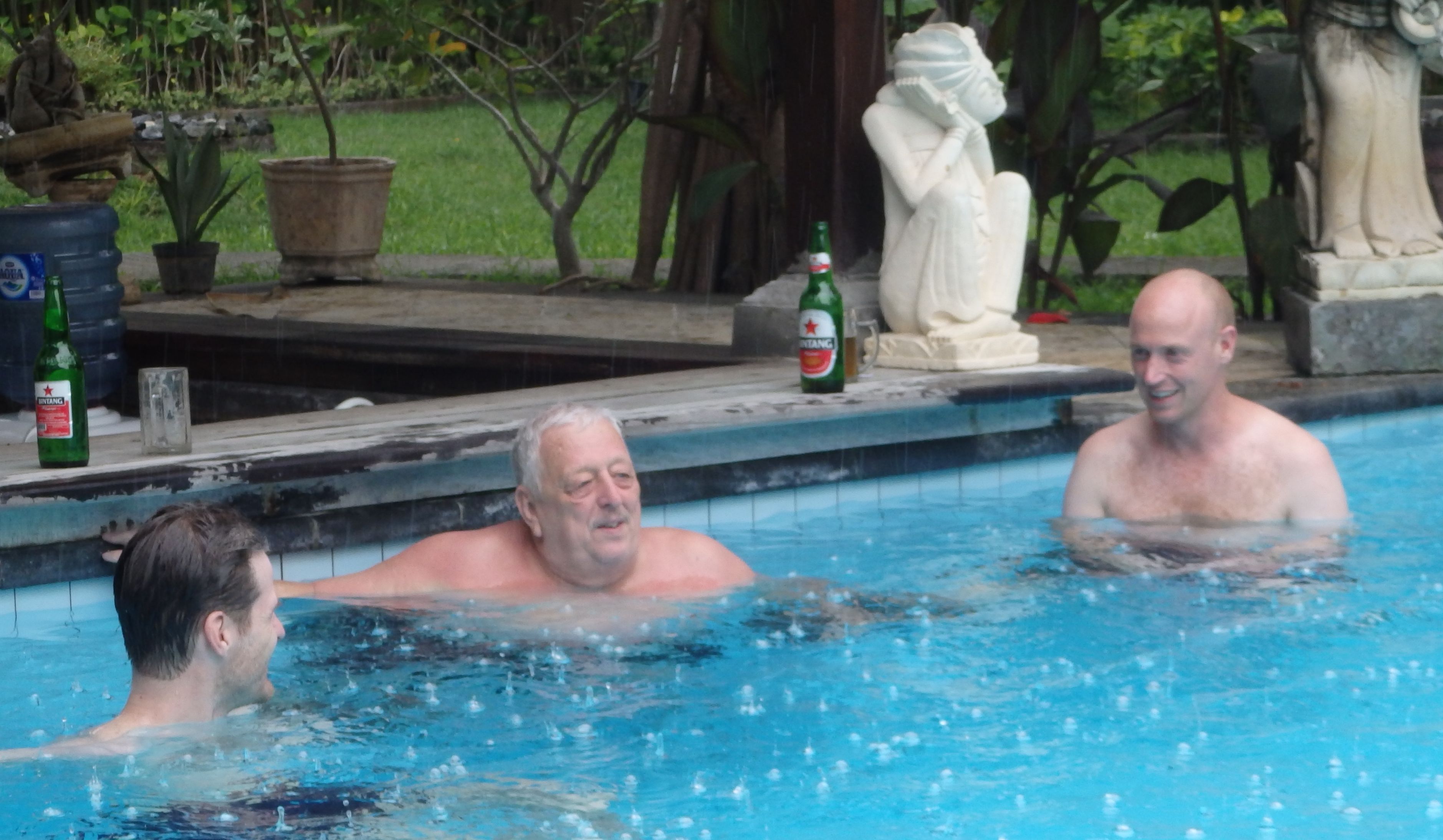 A swimming pool with three people.