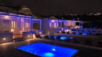 A modern hotel with a pool area, outdoor seating, and a view of the surrounding landscape.