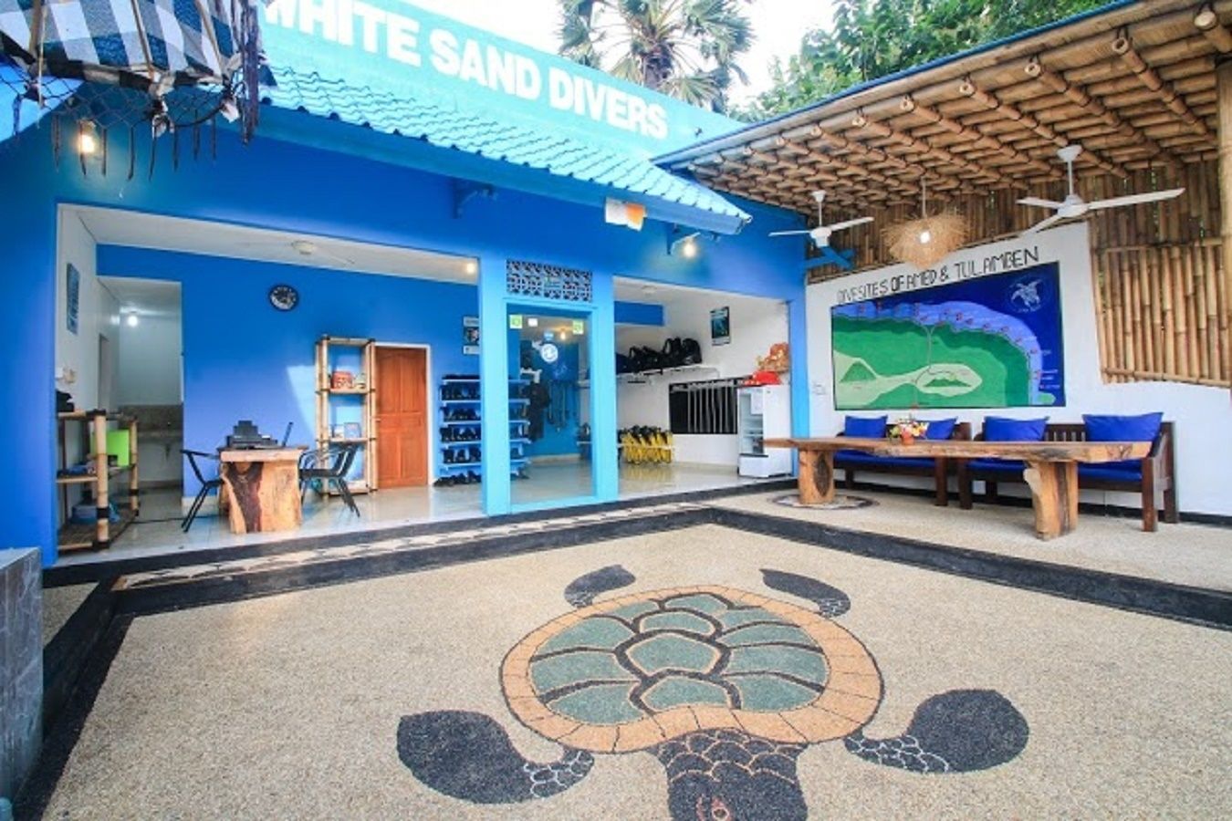 A blue building with a sign reading "WHITE SAND DIVERS" and a map of a beach area.