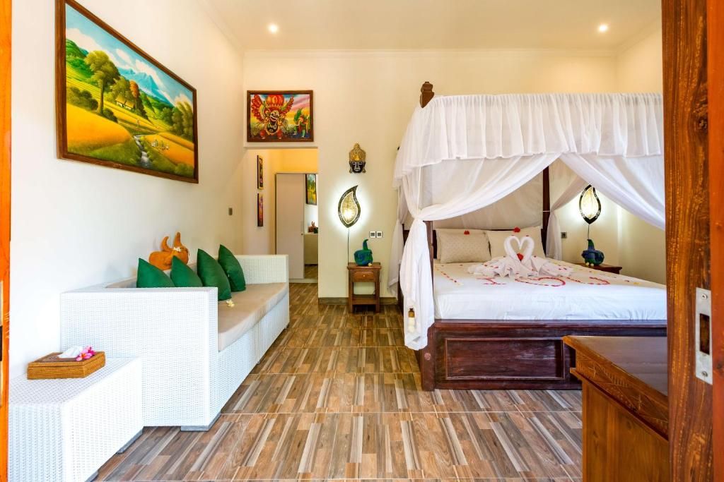 A bedroom with a canopy bed, a sofa, and a painting on the wall.
