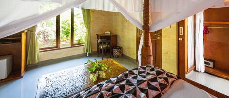 Una habitación con una cama, una mesita con una planta y una ventana con cortinas.
