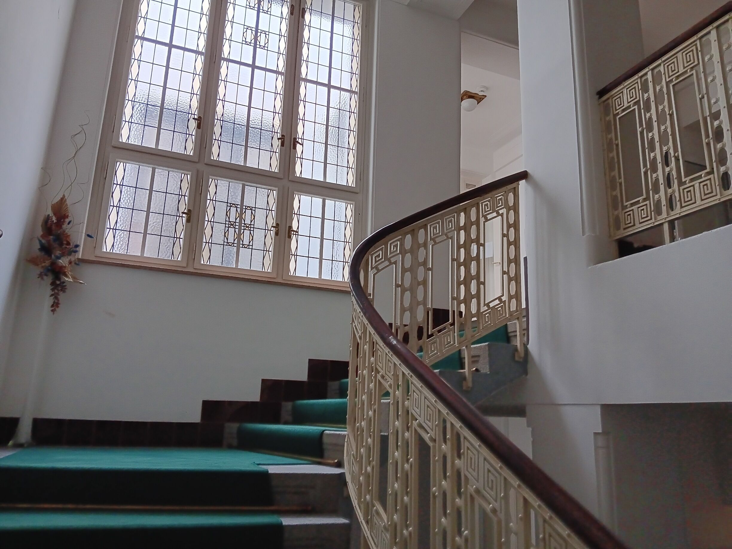 A staircase with green steps and a decorative railing.