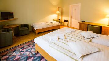 Una camera d'albergo con un letto, una televisione, una scrivania e una sedia.