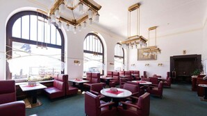 A spacious hotel lobby with high ceilings, large arched windows, and elegant chandeliers. - Hotel U Beránka (Nachod)