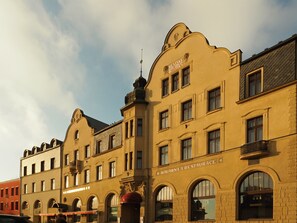 A historic building with arched windows and a sign for 'KAVARNA A RESTAURACE'.