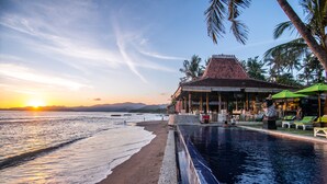 Un complexe hôtelier doté d’une piscine, d’une plage et offrant une vue sur le coucher de soleil.