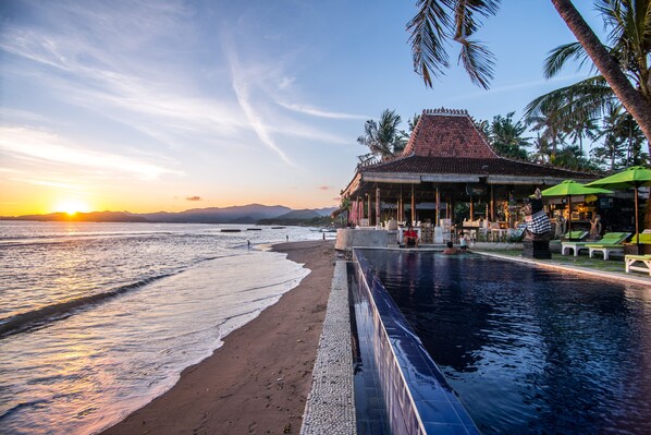 A resort with a pool, beach, and sunset view. - Balisanti Bungalows (Manggis)