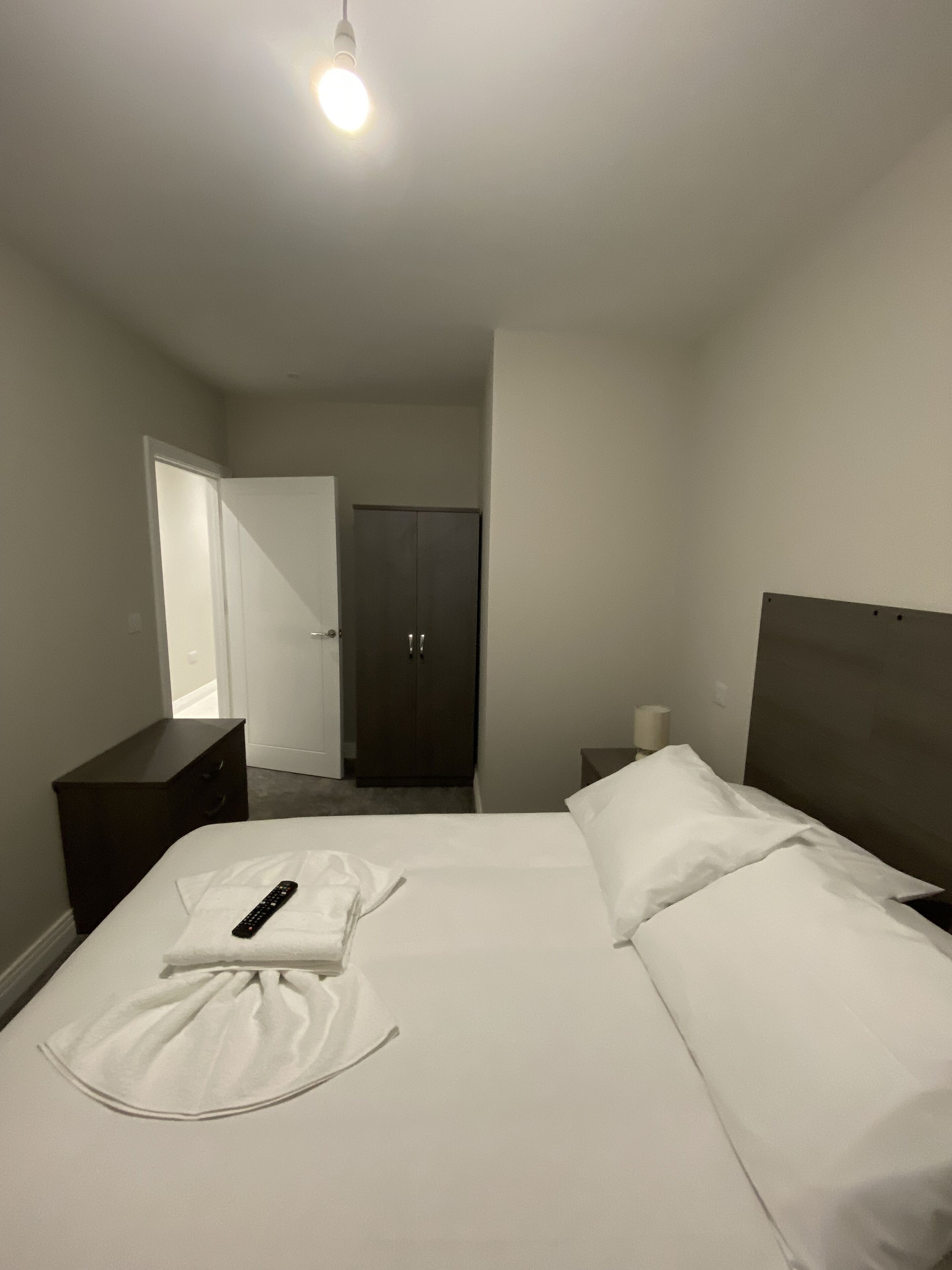 Ein Hotelzimmer mit einem Bett, einem Schminktisch, einem Spiegel und einer Tür.