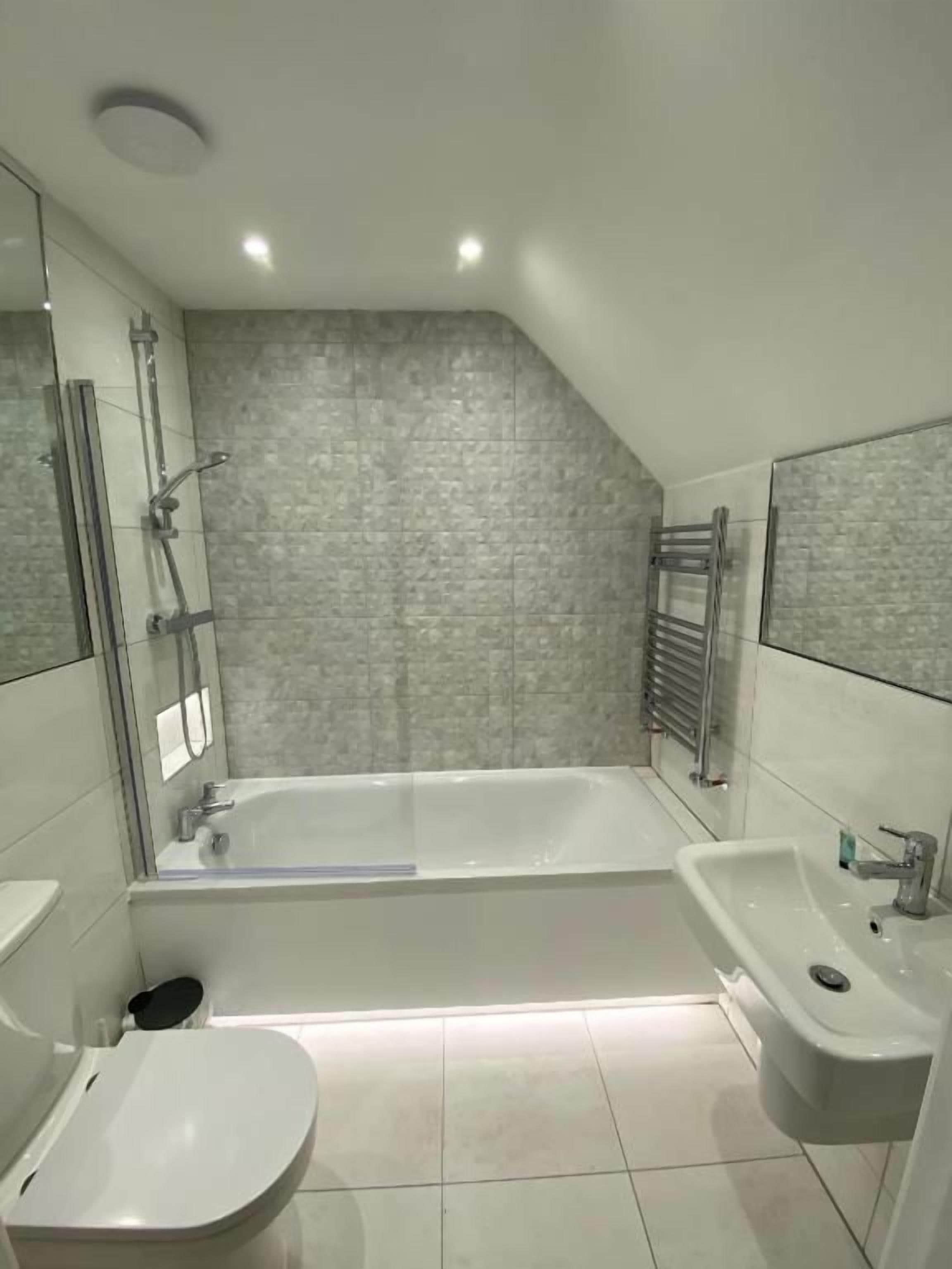 Un bagno moderno con una vasca, un lavandino e un water.