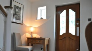 A room with a wooden door, a desk with a lamp, a chair, and a striped carpet. - Canford Crossing (Wimborne)