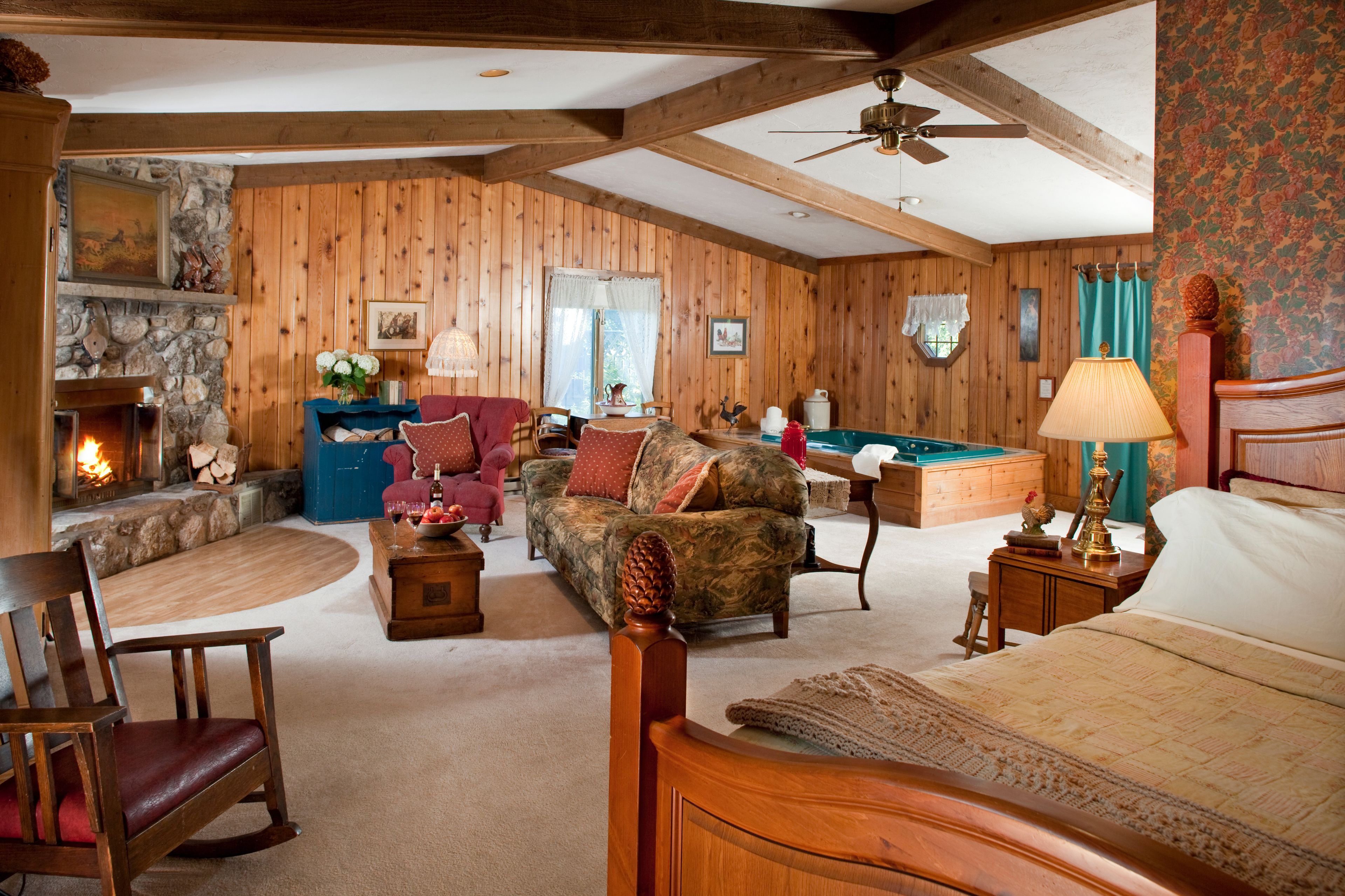 A cozy log cabin interior with a fireplace, a pool table, and a comfortable seating area.