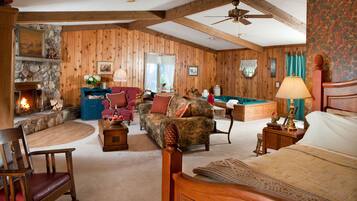 A cozy log cabin interior with a fireplace, a pool table, and a comfortable seating area.