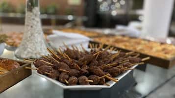 A buffet table with skewered meatballs and other dishes.