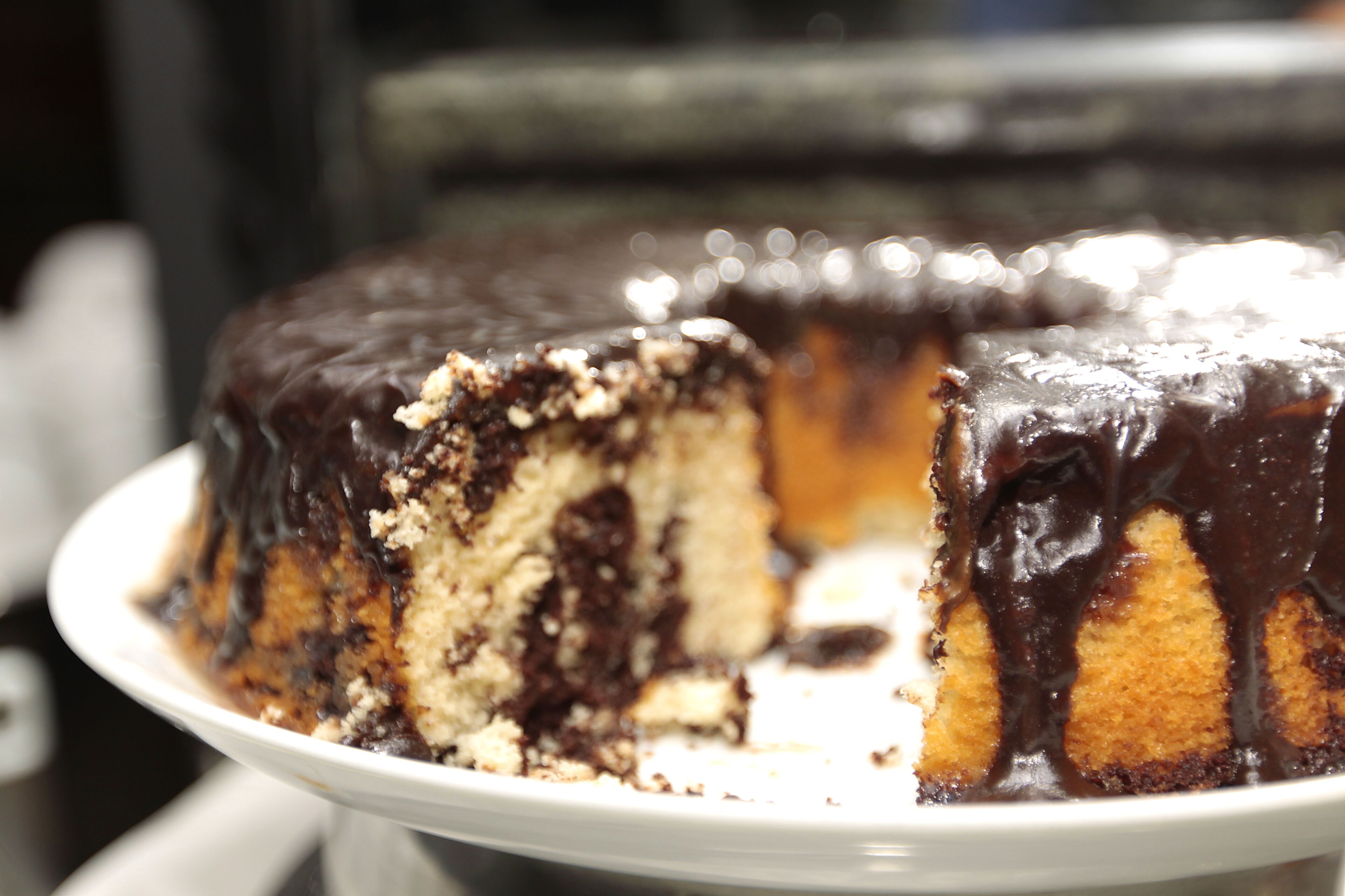A chocolate-covered cake with a slice missing.