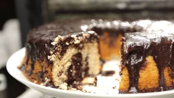 A chocolate-covered cake with a slice missing.