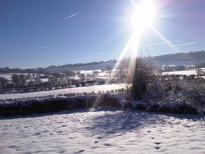A snowy landscape with a clear sky and distant hills. - Upper Letton Farmhouse (Bucknell)