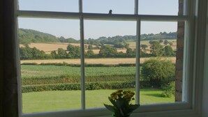 A window with a view of a rural landscape, including fields and trees. - Upper Letton Farmhouse (Bucknell)