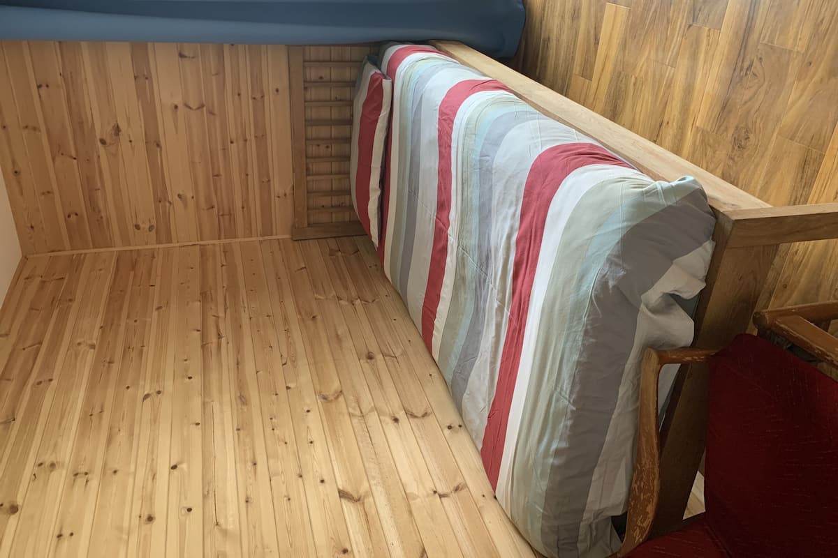 A wooden interior with a bench and a window.