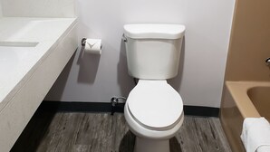 Une salle de bain avec des toilettes, un lavabo et une baignoire.