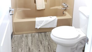 Une salle de bain avec une baignoire, des toilettes et un rideau de douche.