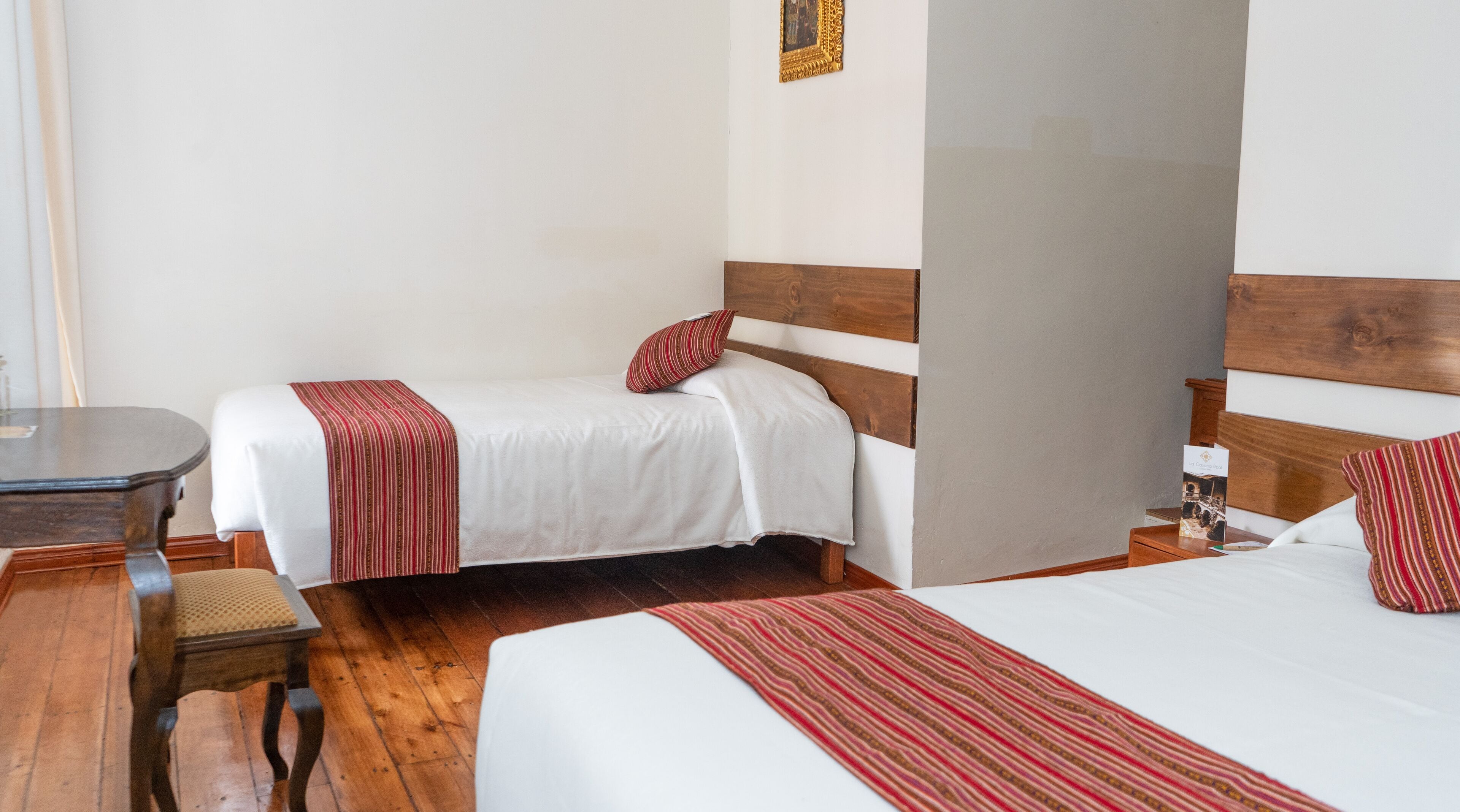 Una habitación de hotel con dos camas individuales, un escritorio de madera y una silla.