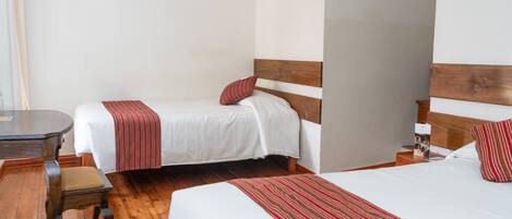 Una habitación de hotel con dos camas individuales, un escritorio de madera y una silla.
